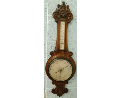 A Victorian carved oak aneroid barometer, with silvered dial, 90cm high