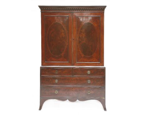 A George III strung mahogany linen press,with an arcaded cornice over two panelled doors, two short and two long drawers and 