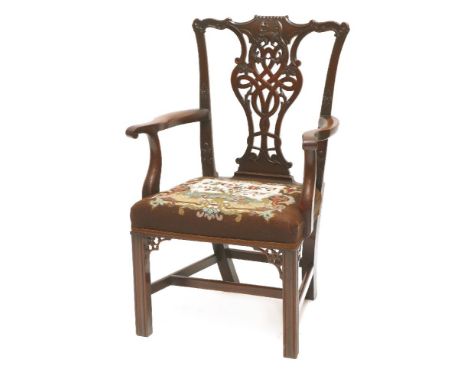 A Chippendale-style mahogany elbow chair,the shaped back with an ornately carved and pieced vase-shaped splat, scrolled arms,