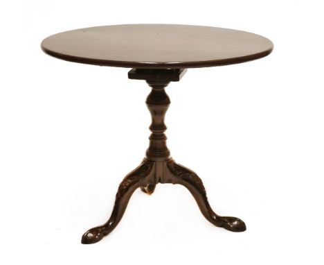 A mahogany tripod table, with a single piece top on a baluster column with birdcage action, carved outswept legs and claw fee