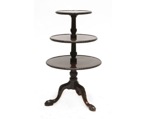 A George III mahogany three-tier dumb waiter,the graduated, dished, circular and rotating tiers with carved edges, the column