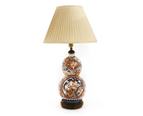 An Imari double-gourd vase,late 19th century, painted in the traditional style, converted to a table lamp, on a wooden stand,