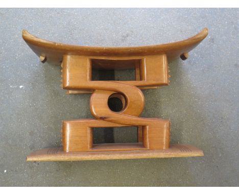A Nigerian hardwood carved Ashanti stool with shaped top above a decorated pierced support, circa 1960's