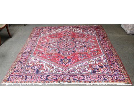 Heriz CarpetNorth West Iran, circa 1960The tomato red field of angular vines centred by a cruciform medallion framed by serra