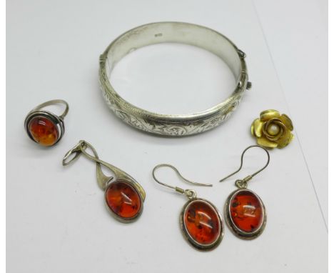 A silver bangle, silver and amber earrings, pendant and ring, size Q, and a rose pendant 