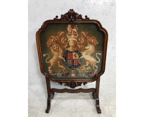 Antique furniture, later Victorian fire screen of carved flame mahogany on legs  with a glazed central panel  covering a wool
