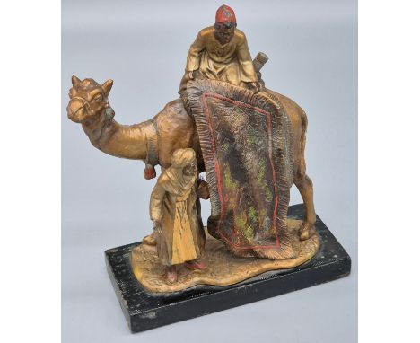 An antique Austrian, Bergmann style cold painted spelter table lighter in the form of a carpet seller with camel and two figu