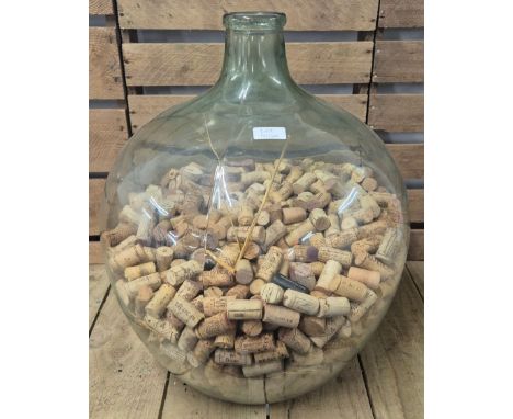 Large vintage Demijohn Carboy containing a quantity of wine corks. 