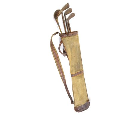 Set of four vintage golf clubs, including three irons and driver, in a canvas bag