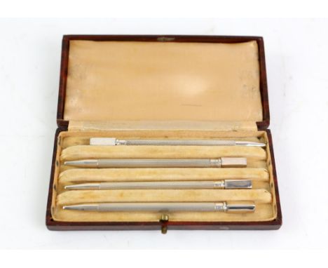 Set of four engine turned bridge pencils, cased, marked Sterling Silver, 9cm long each