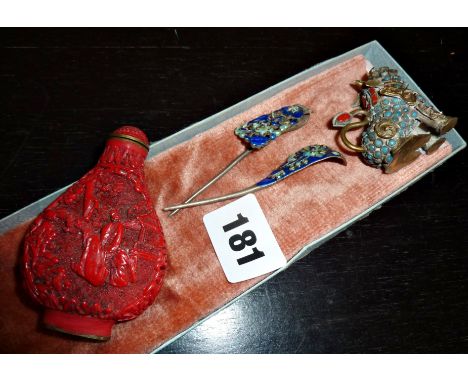 Pair of Oriental enamel hair clips, a carved cinnabar snuff bottle, and an ornate brass miniature dog of Fo 