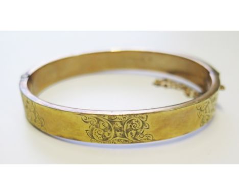 A 9 carat gold bangle with cased decoration