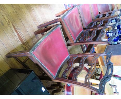 A set of four George III style ladder back dining chairs, the pierced rails over dished seats on gadrooned moulded square leg