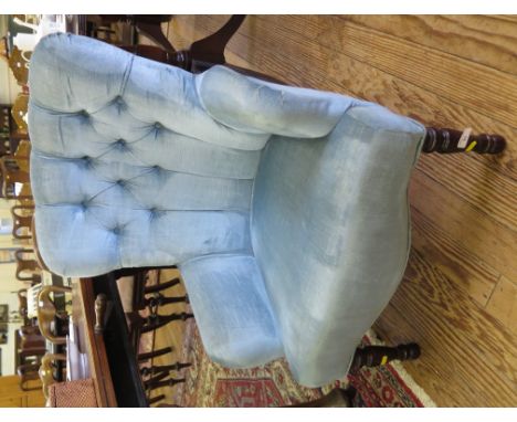 A Victorian style upholstered lady's armchair, the button upholstered back above turned tapering legs