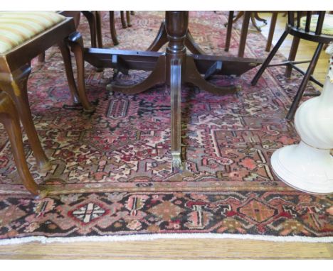 A Heriz carpet, the green and black central medallion on a red ground with spandrals, filled with stylised flowers, within a 