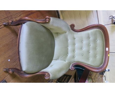 A Victorian mahogany spoonback armchair, the scrolling button back on moulded scroll supports and pot castors