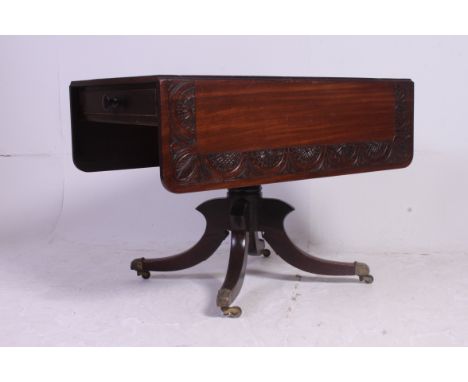 A 19th century Regency mahogany sofa table, Raised on quadruped base with brass cap castors having a rectangular top with dro