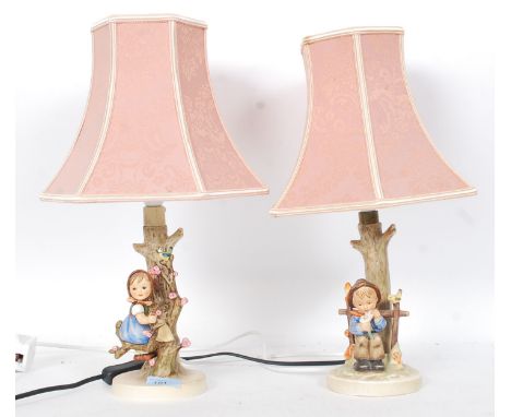 Two vintage Goebel Hummel ceramic table lamps, one in the form of a young girl in a flowering branch, another with children b