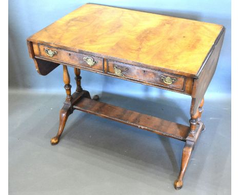 A Circa 1920's Walnut Sofa Table with a shaped drop flap top above two frieze drawers with brass handles raised upon twin end