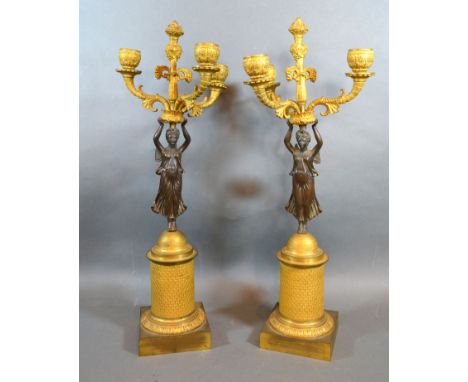 A Pair of Late 19th Early 20th Century French Patinated Bronze and Gilt Metal Three Branch Candelabrum each with a figural co