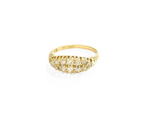 An 18 Carat Gold Diamond Cluster Ring, two rows of old cut diamonds in yellow claw settings, to a scroll shoulder plain polis