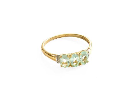 A 9 Carat Gold Paraíba Tourmaline Ring, three oval cut paraíba tourmalines in yellow claw settings, flanked by trios of eight