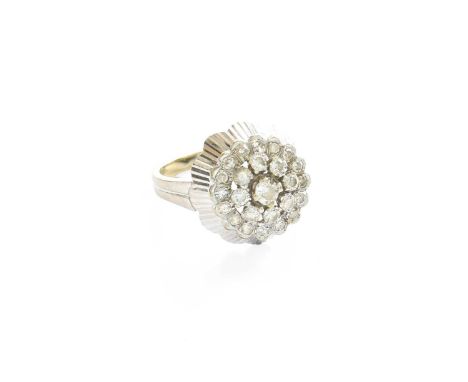 A Diamond Cluster Ring, the central raised round brilliant cut diamond within a border of round brilliant cut diamonds, to an