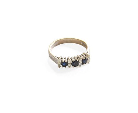 An 18 Carat White Gold Sapphire and Diamond Ring, three round cut sapphires spaced by pairs of round brilliant cut diamonds, 