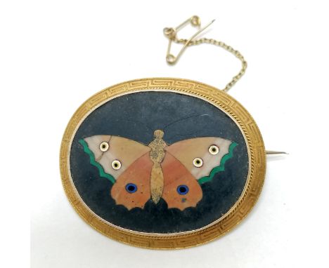 Antique pietra dura butterfly panel unmarked gold brooch with Greek key pattern around the rim and has a metal safety chain -