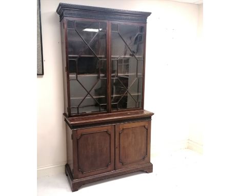 Georgian astragal glazed mahogany bookcase. Three adjustable height shelves over two panelled cupboard doors opening to revea