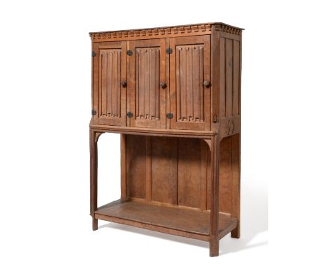 A Thomas ''Gnomeman'' Whittaker Oak Cupboard, the shaped rectangular top over three carved linen-fold doors, each enclosing a