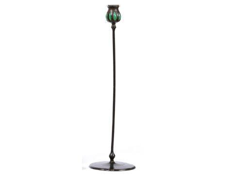A Tiffany Studios Patinated Bronze Candlestick, circa 1900, the baluster sconce with green glass insert, on a slender column 