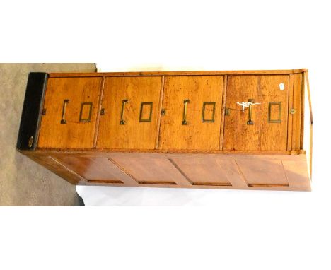 An Early 20th Century Light Oak Filing Cabinet, with four drawers, brass handles and escutcheons, panelled sides on ebonised 