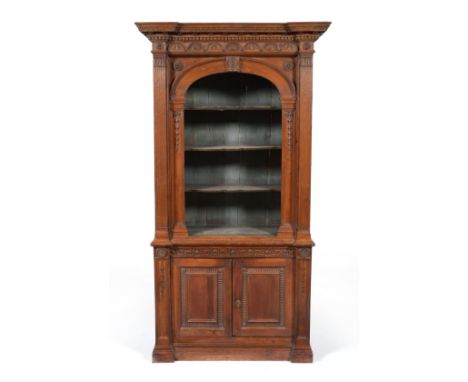 A Stained Pine Display Cabinet, of architectural form, with a dentilled cornice and lunette frieze over an arched recess cont