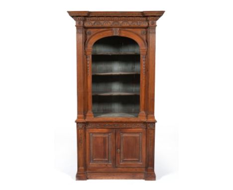 A Stained Pine Display Cabinet, of architectural form, with a dentilled cornice and lunette frieze over an arched recess cont