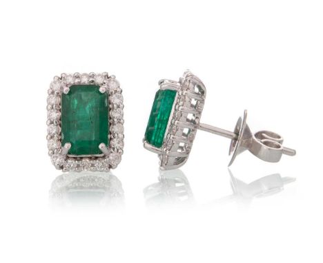 PAIR OF EMERALD AND DIAMOND EARRINGS, set with rectangular step cut emeralds within a diamond halo, in eighteen carat white g