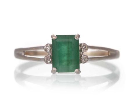 EMERALD AND DIAMOND RING, the central emerald flanked by small diamonds, in nine carat white gold, size Q 1/2Qty: 2gHas been 