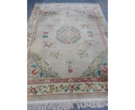 A large Chinese wool rug, the cream field with a central foliate design with a surround of Oriental motifs 