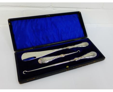 An Edwardian leather cased three piece shoehorn and button hooks set with makers mark for Colen Hewer Cheshire, Chester 1907 