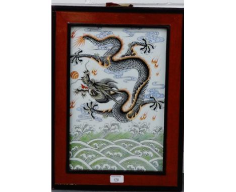 A rectangular Chinese ceramic plaque with a Dragon chasing the Pearl of Wisdom pattern, framed, 26 x 42cm 