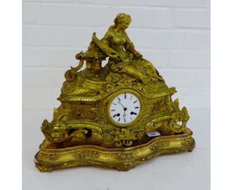 A late 19th early 20th century gilt brass mantle clock with circular enamel dial with Roman numerals and retailers mark T & J