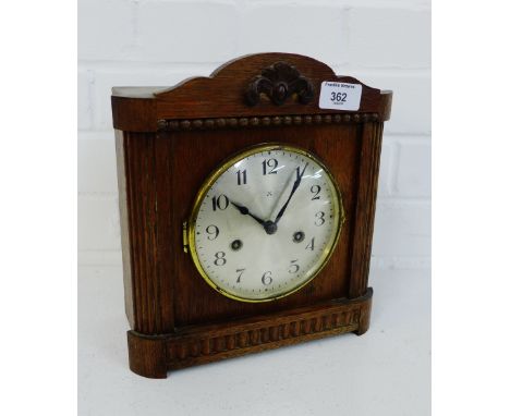 An oak framed mantle clock with silver dial and Arabic numerals, 27cm high