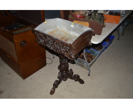A late 19th Century carved wooden planter on floral decorated tripod baluster base