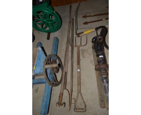 A quantity of long handled tools including a pitch fork