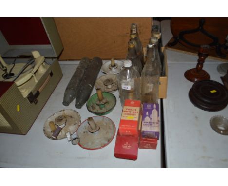 A collection of various named glass bottles, enamel chamber sticks, candles etc.