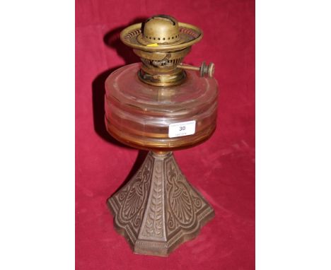 A cast iron base and glass reservoir oil lamp