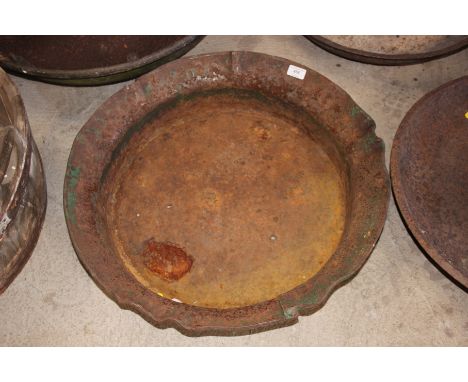 A cast iron circular planter with ornate edge 