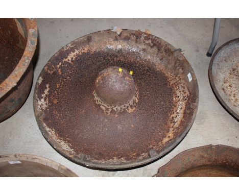 A circular cast iron pig trough