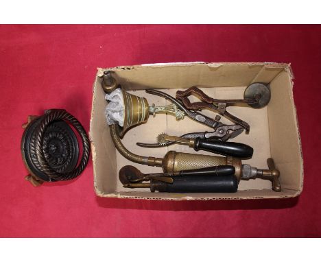 A box of miscellaneous metalware to include 19th Century iron door knocker; brass pump; candle holder; Cannula etc.