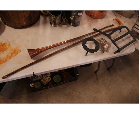 Two metal and one brass trivets, a long copper hunting horn and a walking stick